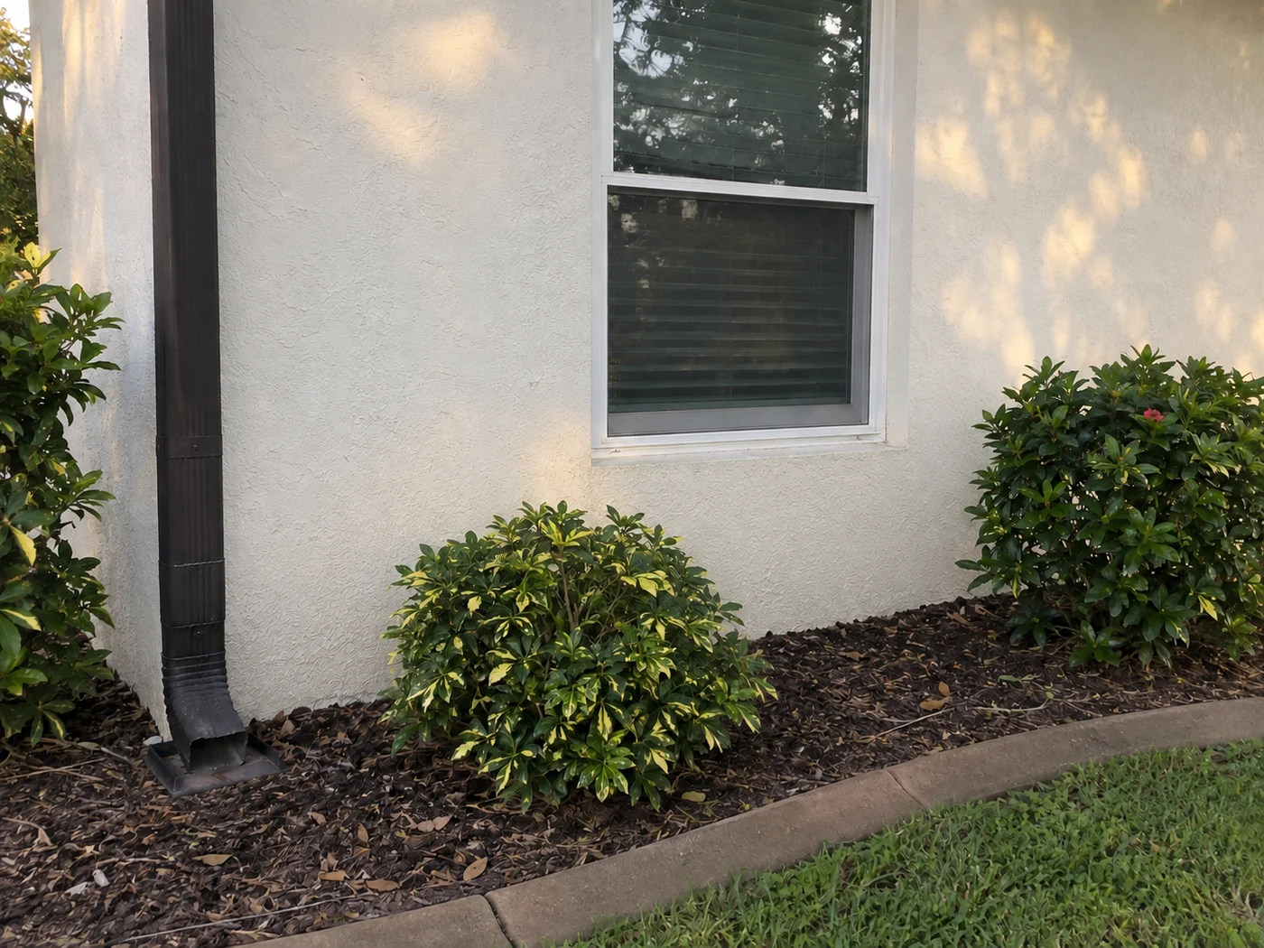 The same pale stucco house wall after ordinary exterior buildup has been washed away